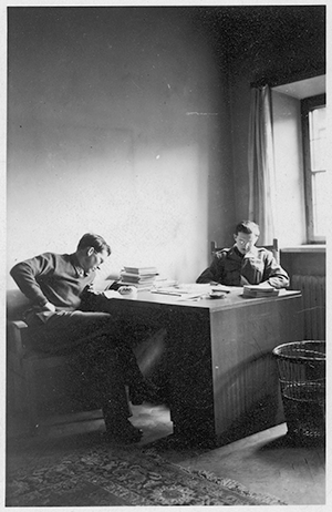 Photograph of Edgar Bowers and unidentified man sharing a desk in Berchtesgaden (circa 1945).